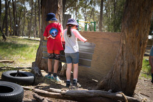 Two children working on hut building