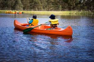 Boys padding in orange canoe