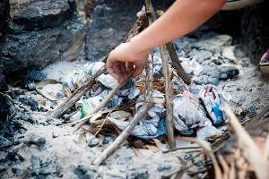 Student building a campfire with paper and sticks