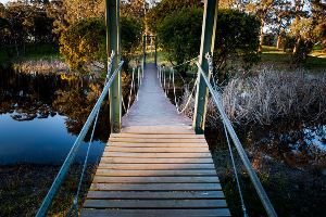 Wooden suspension bridge over dam