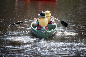 Two boys padding in a green canoe