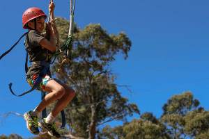 Boy jumping off flying fox