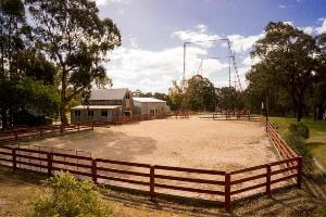 Sporting sand arena next to the barn and giant swing