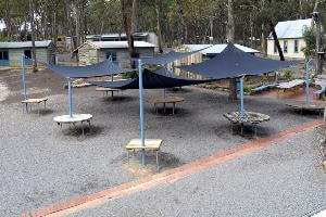 Outside meeting area with tables under shade sails