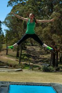 Girl doing a star jump on our olympic trampoline 